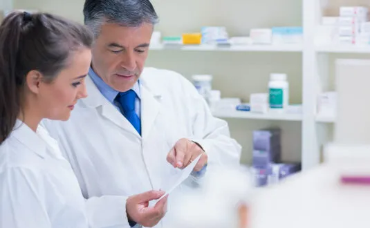 Pharmacist explaining a prescription to his trainee